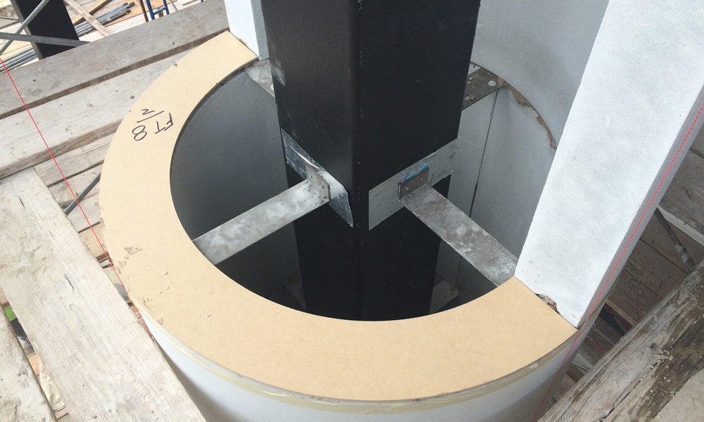 Cast stone pieces for column secured using steel plates and anchors